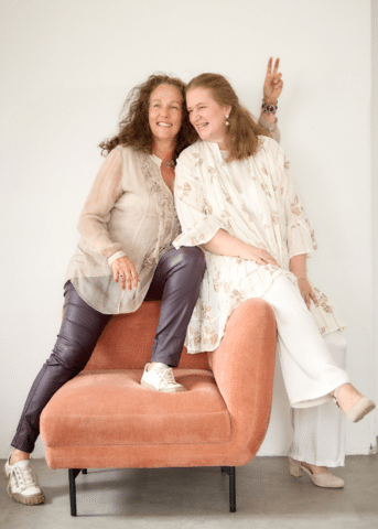 Alexandra und Ulrike, Gründerinnen von Das Rote Zelt, auf einem lachsfarbenen Sessel